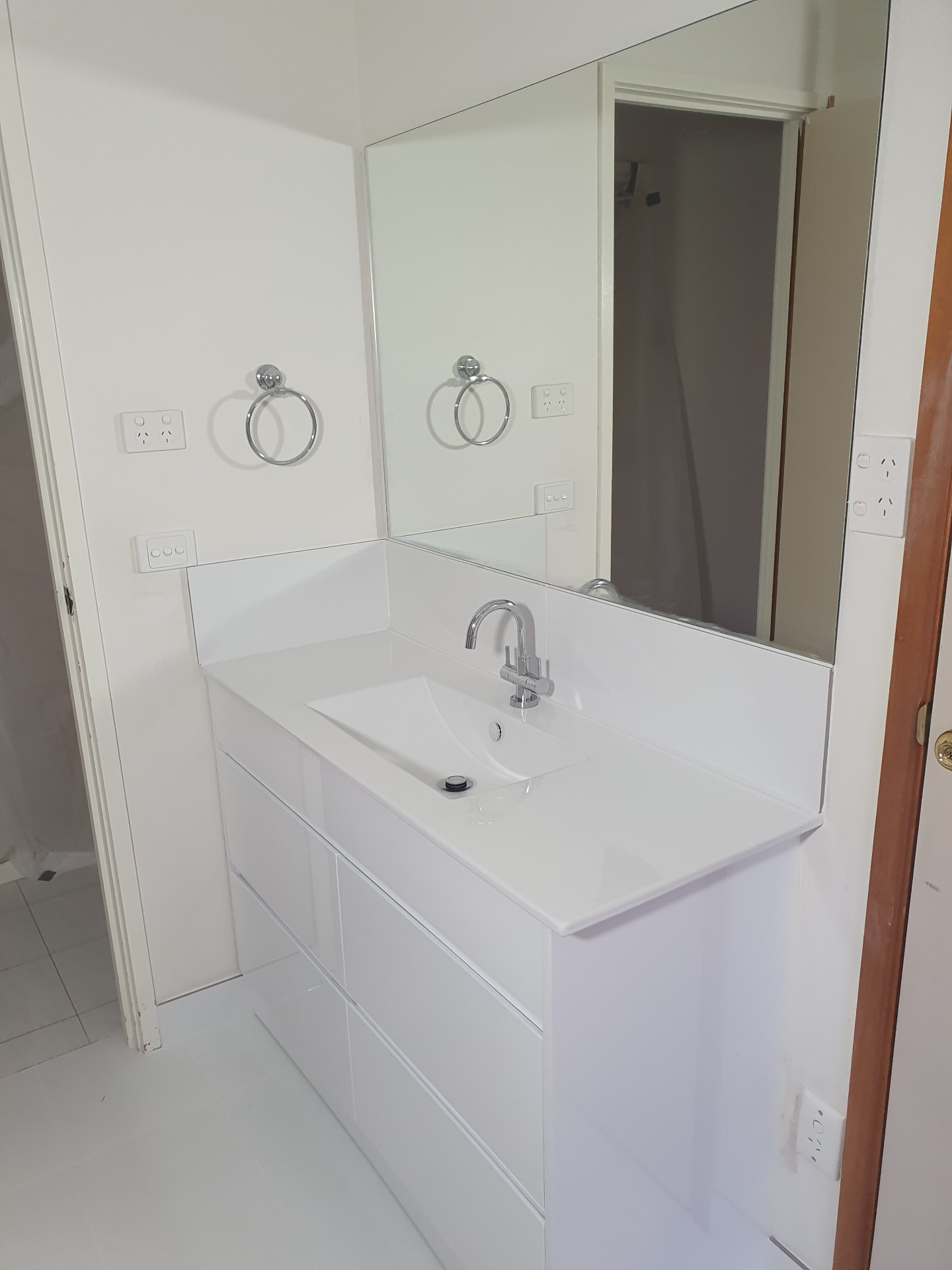 Sleek white vanity with integrated basin, chrome mixer & full-height mirror