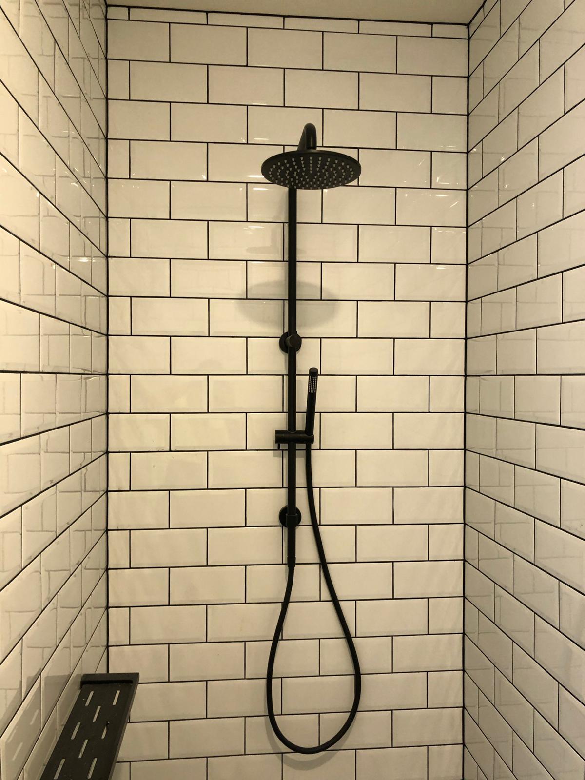 Subway-tiled shower with black grout & matte black rail shower