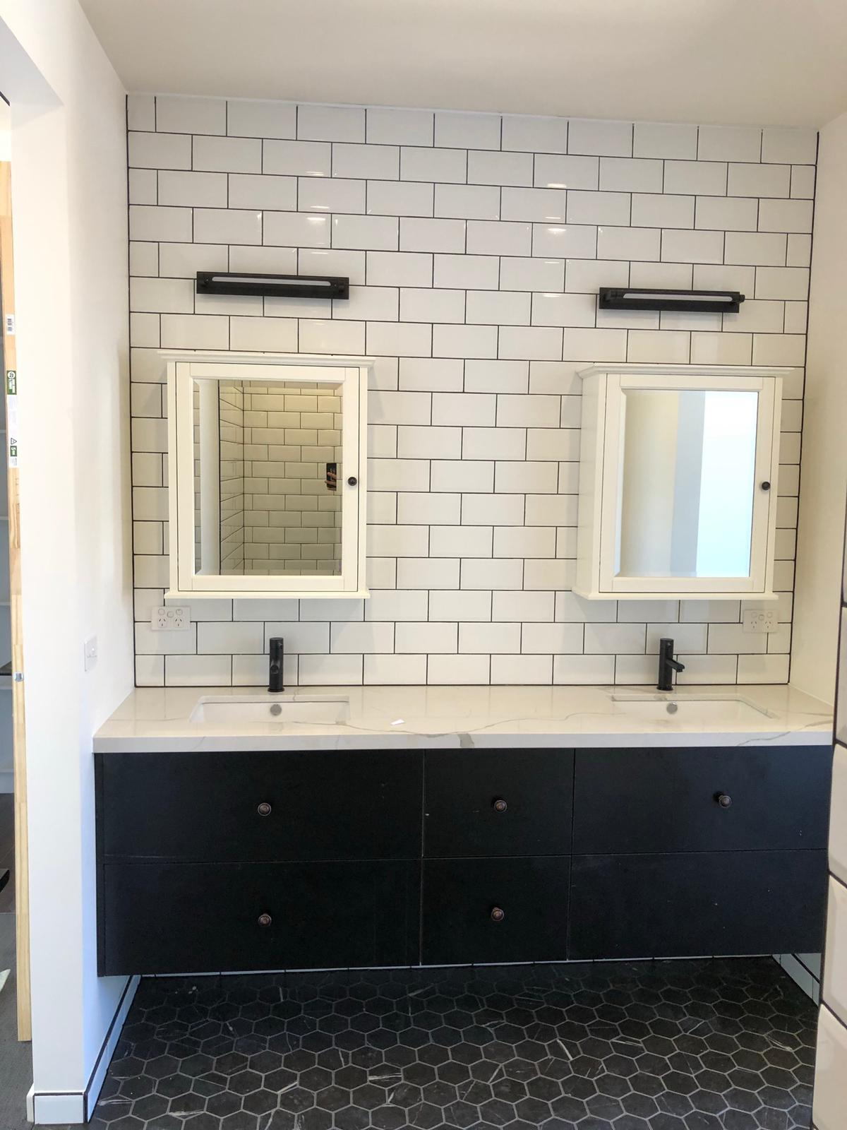 Double vanity with stone benchtop, black cabinetry & framed mirror cabinets
