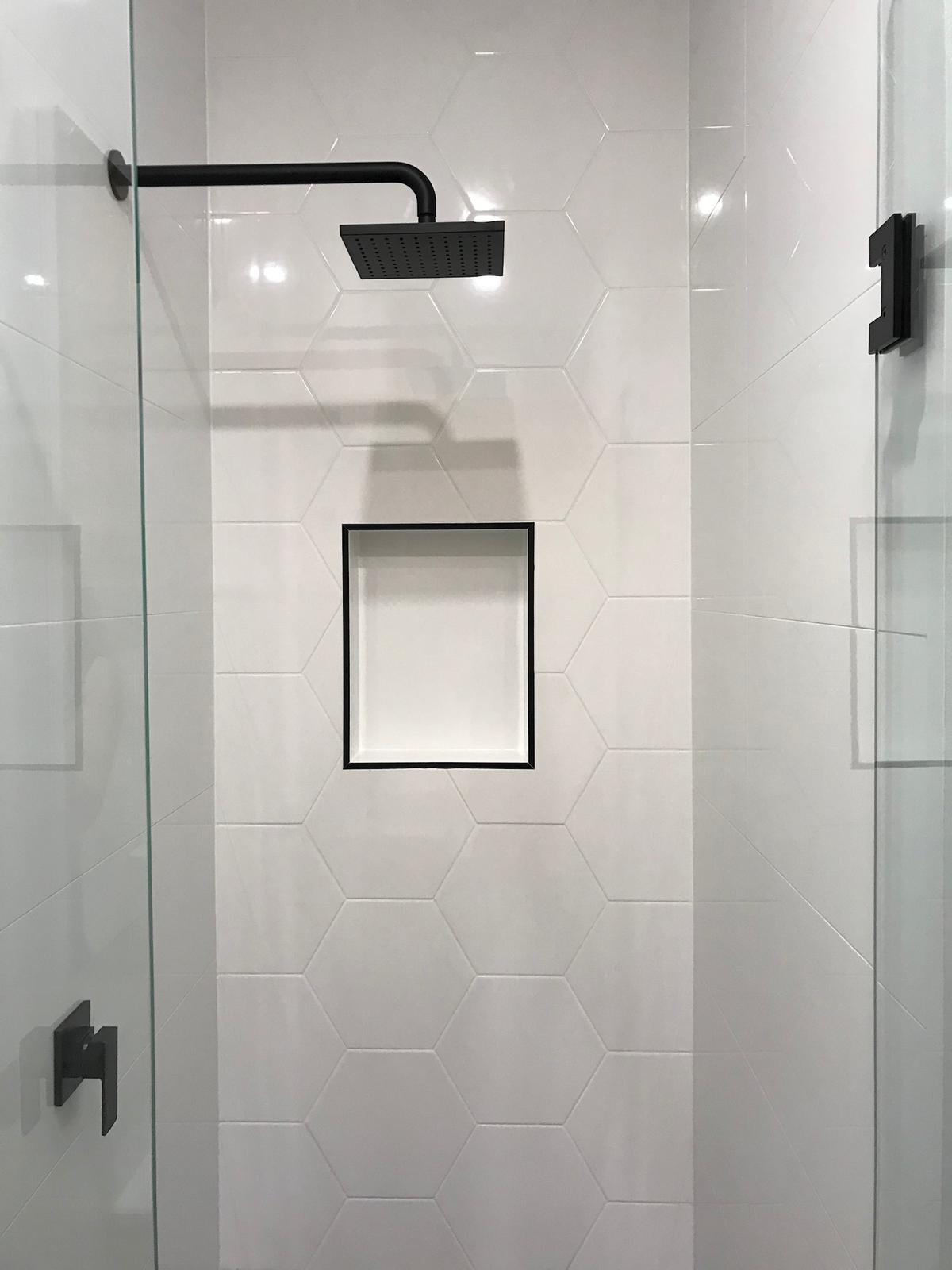 Hexagonal-tiled shower with feature niche & matte black shower head