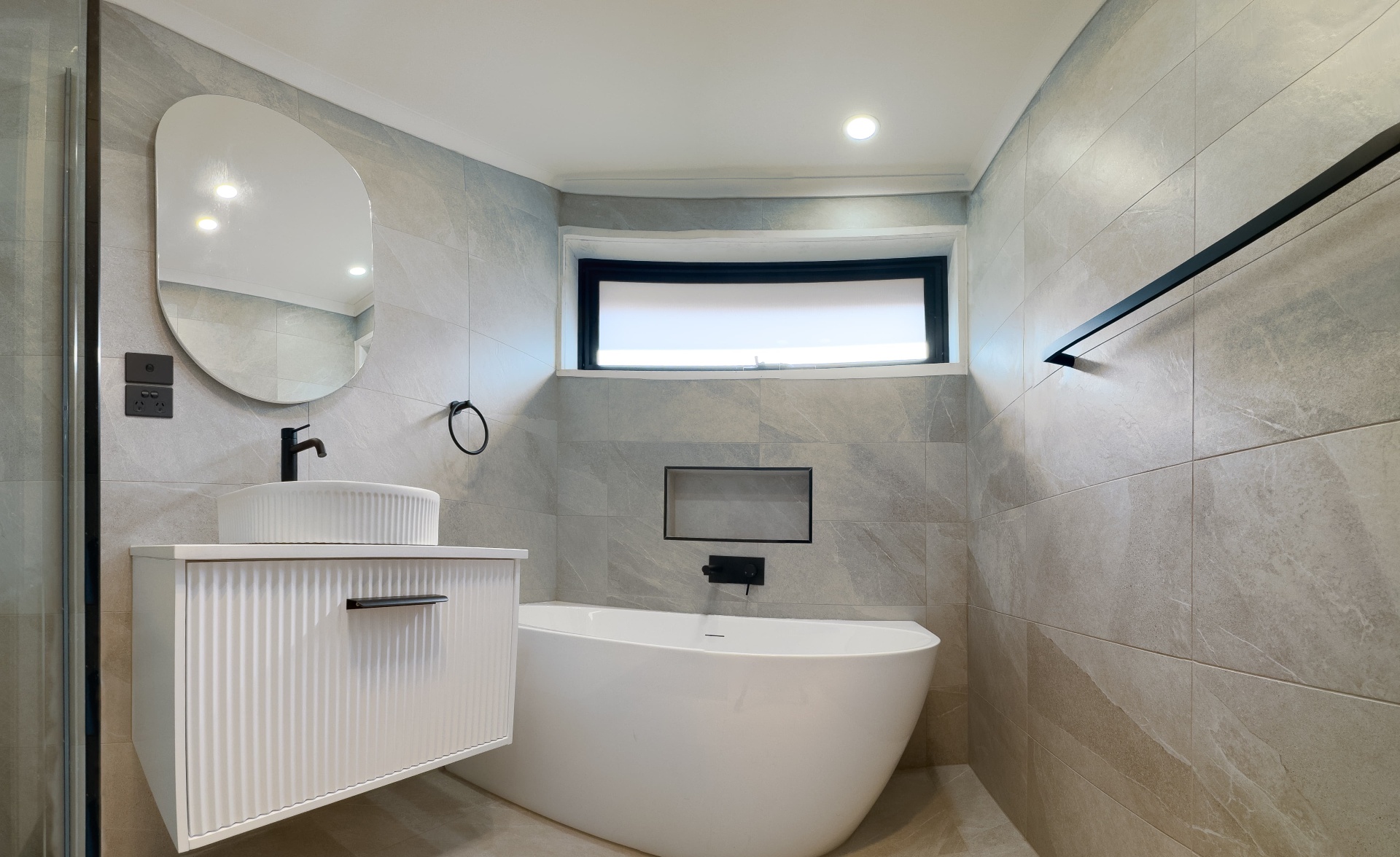 Freestanding bath with niche and fluted vanity