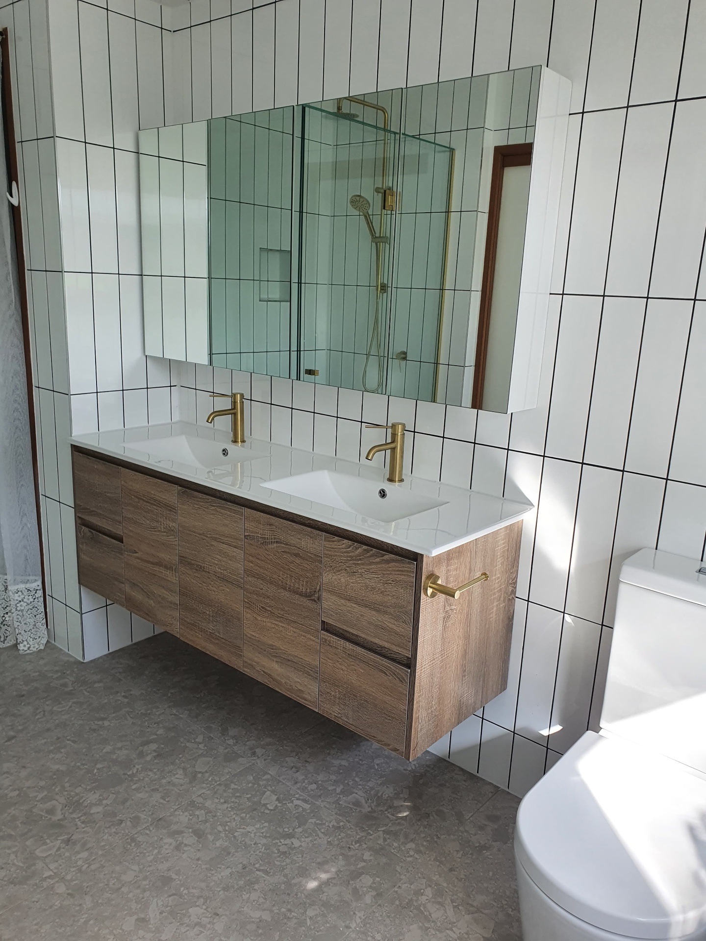Floating timber double vanity with stone top and brushed brass tapware