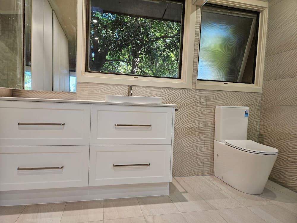 Shaker vanity with vessel basin and wall-hung toilet