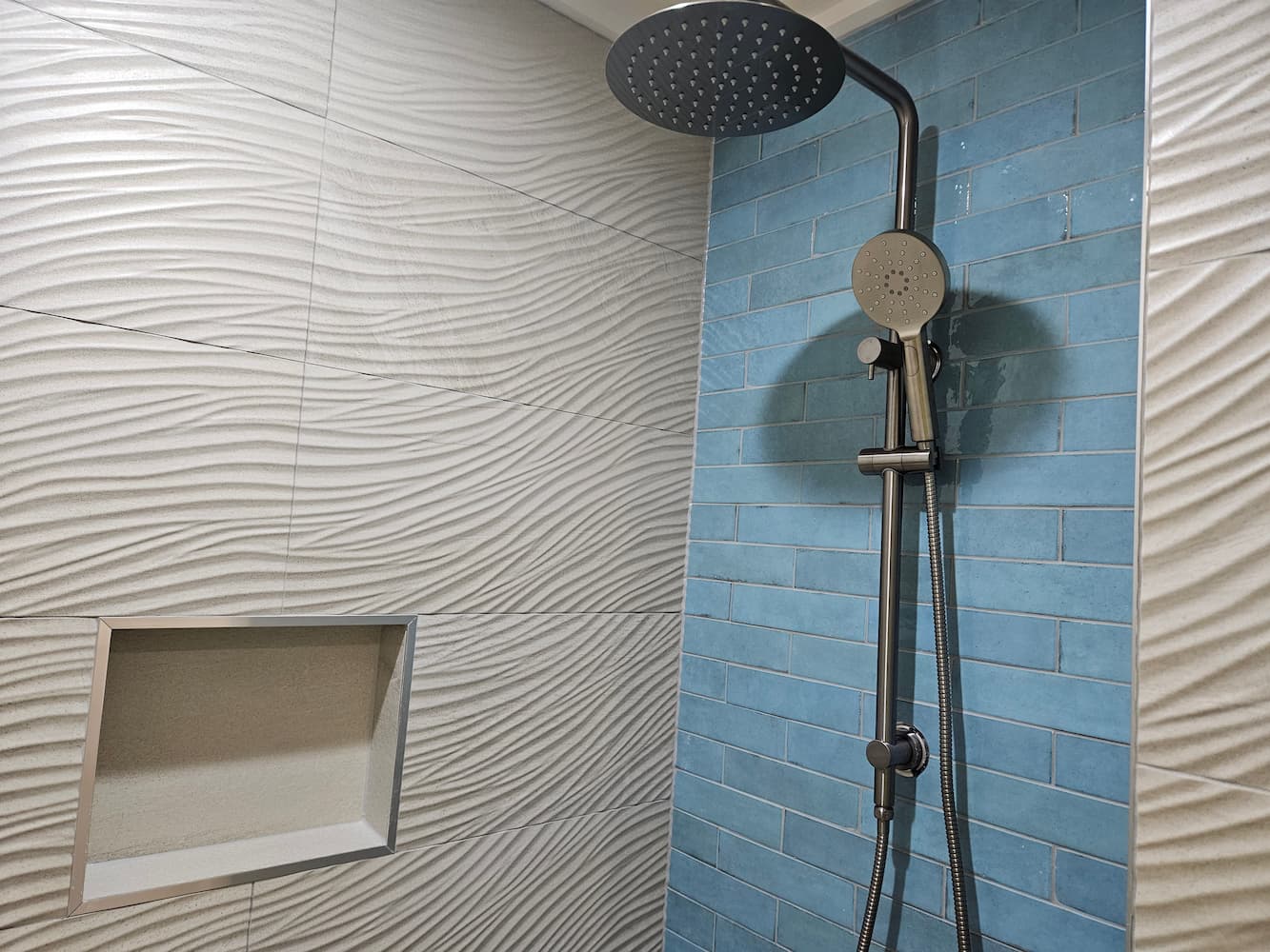 Rain shower against blue brick feature wall with niche